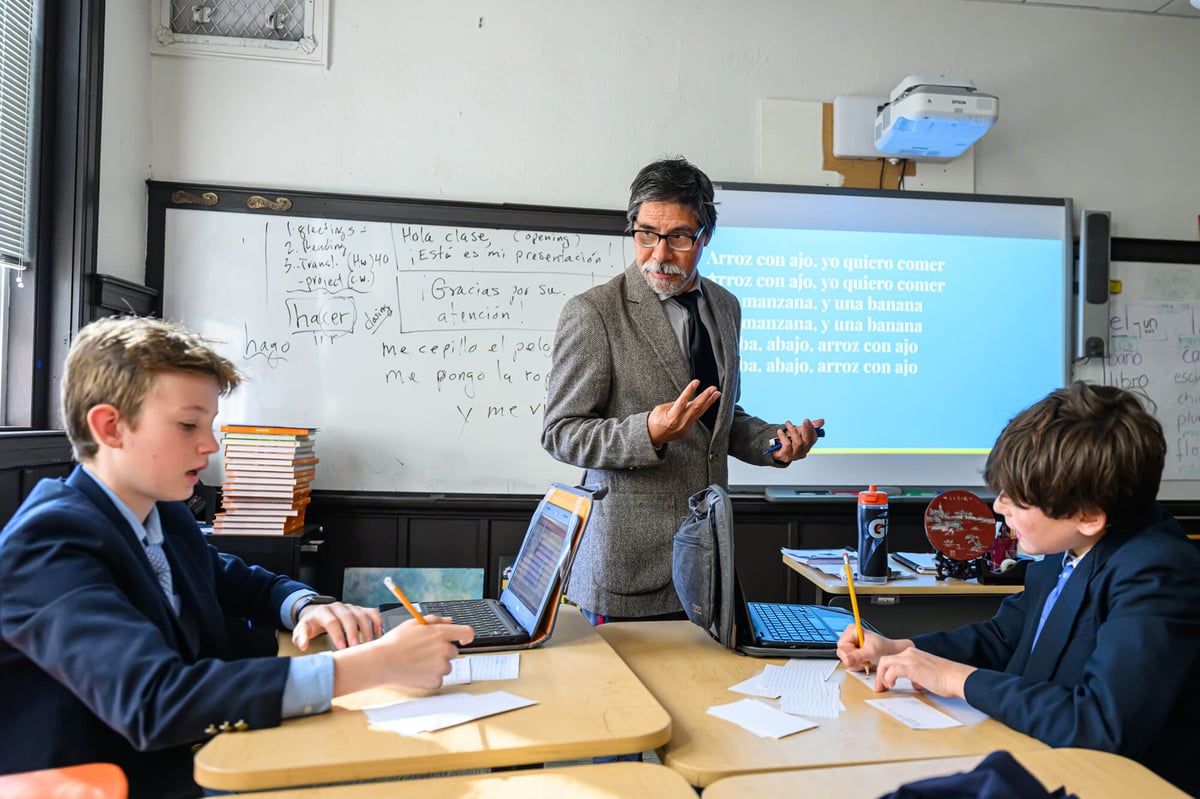 a male teacher lectures sitting students