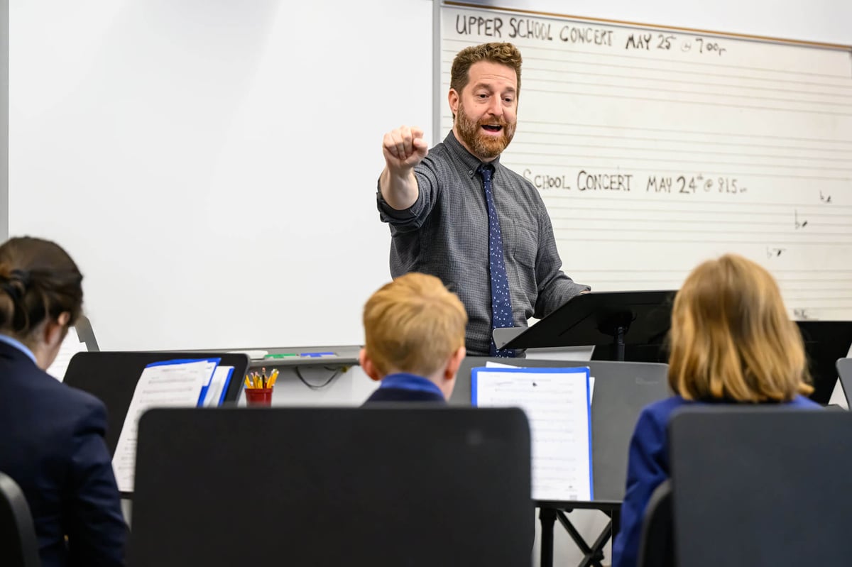 a male teacher lectures in a band class